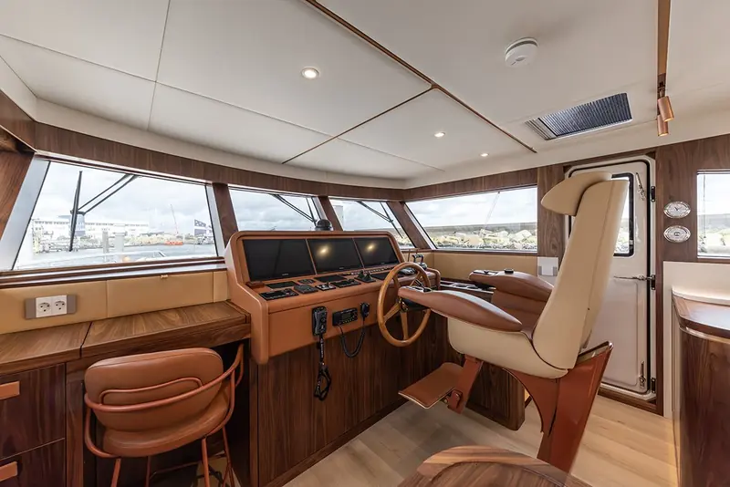 The pilothouse helm station, positioned for a couple running long passages themselves rather than handing the boat to a professional crew.