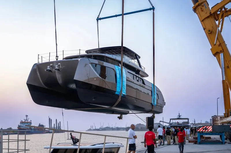 An 88 Ultima hull comes off the slings, still wrapped, at delivery - the yard's own send-off for a boat headed straight to an owner rather than a show stand.