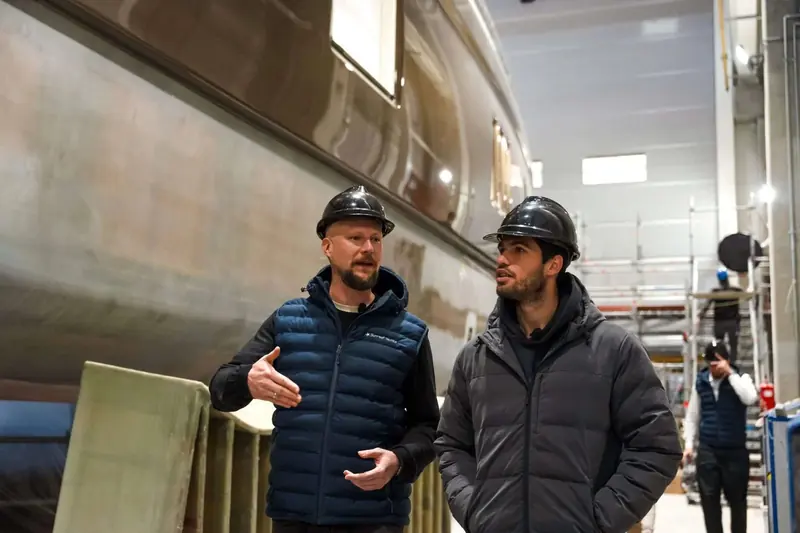 Alcaraz tours the hull mould at the yard with a Sunreef build manager. The composite structure behind them is the same sandwich layup used across the Ultima range.