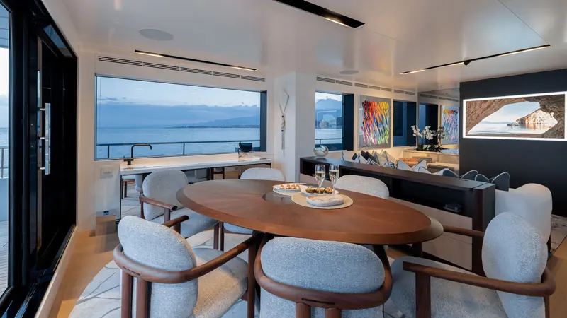 A galley and casual dining area looks out over the water at dusk.