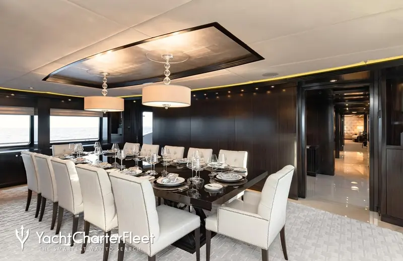 The formal dining room seats twelve, panelled in the same dark wood as the rest of the main deck.