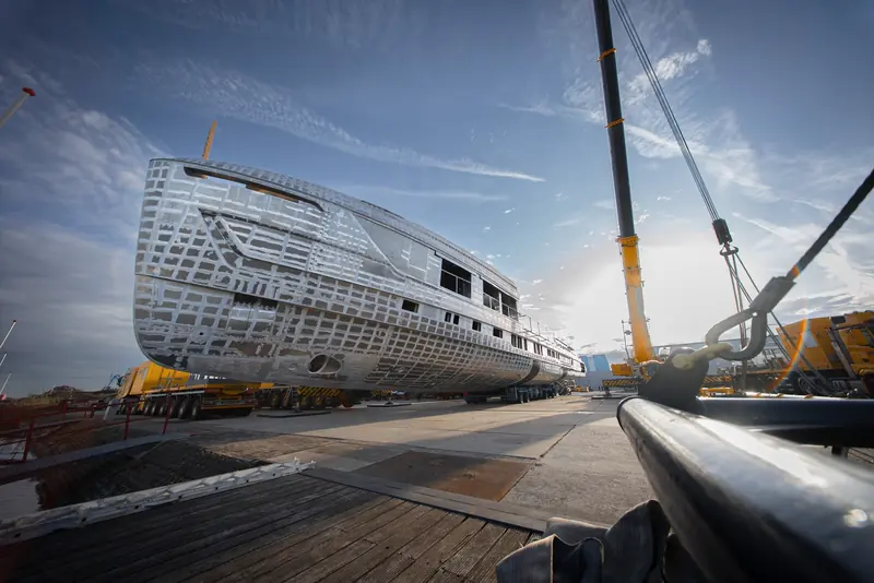 A view from beside the crane hook shows the long profile of Zen's raised pilothouse structure against the sky.
