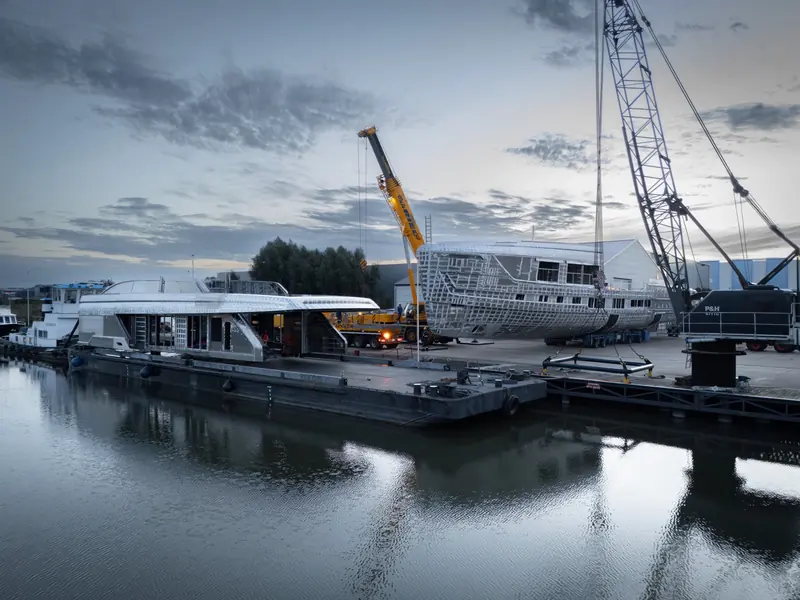 Cranes work beside the yard's canal as the aluminium structure is moved into position.