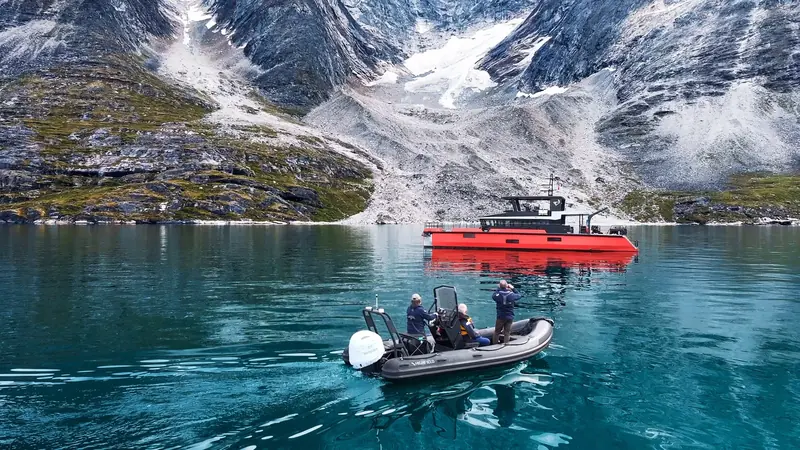 Vanguard's tender crew photographs her at anchor in a Greenland fjord, the voyage Northrop and Johnson cites as proof of her cold-water range.
