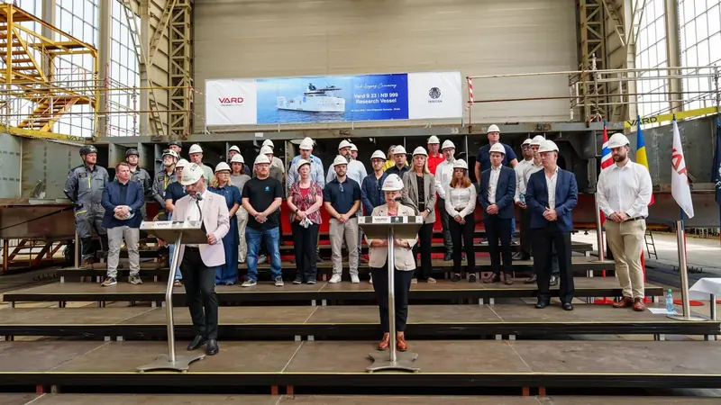 Vard and Inkfish staff at the RV6000 keel-laying inside Vard's Braila, Romania hall on 4 June 2026, the banner behind them naming the hull Vard 9 33 / NB 999.