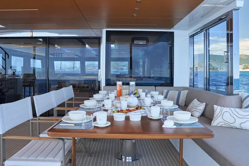 Breakfast laid in the covered aft saloon, glass doors open to the anchorage off Imperia where the yacht is currently listed for sale.