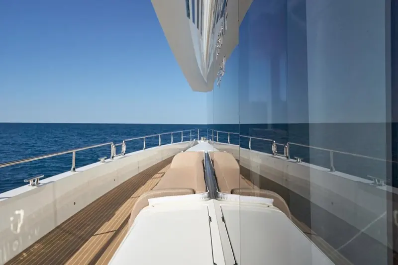 Looking forward from the flybridge over the foredeck sun pads, the view a buyer sees in Atraversia's current for-sale photography.