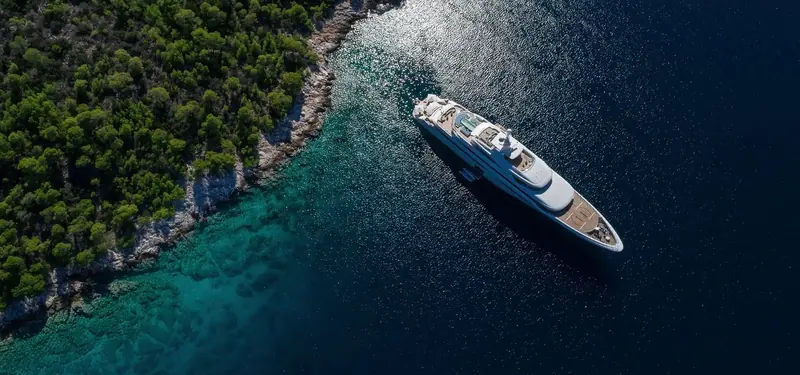 An aerial view of Casa approaching a rocky Mallorca anchorage, the pairing's home cruising ground.