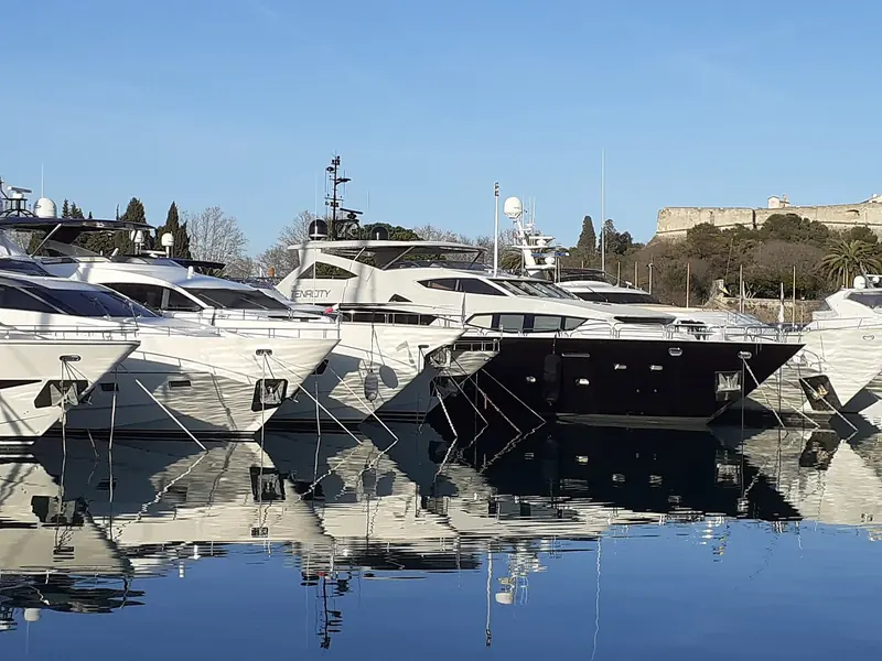 Yachts moored bow-to at Port Vauban - the kind of harbour where a single boat can carry several brokers' business cards over its lifetime as its central agency changes hands.