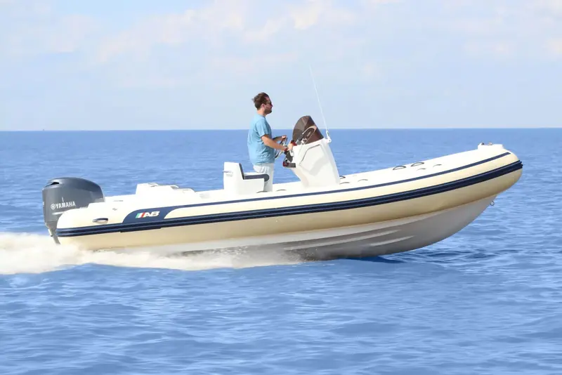An AB Inflatables Oceanus running with two people aboard, fishing rods rigged in rocket launchers, off the fibreglass-hulled superyacht tender line.