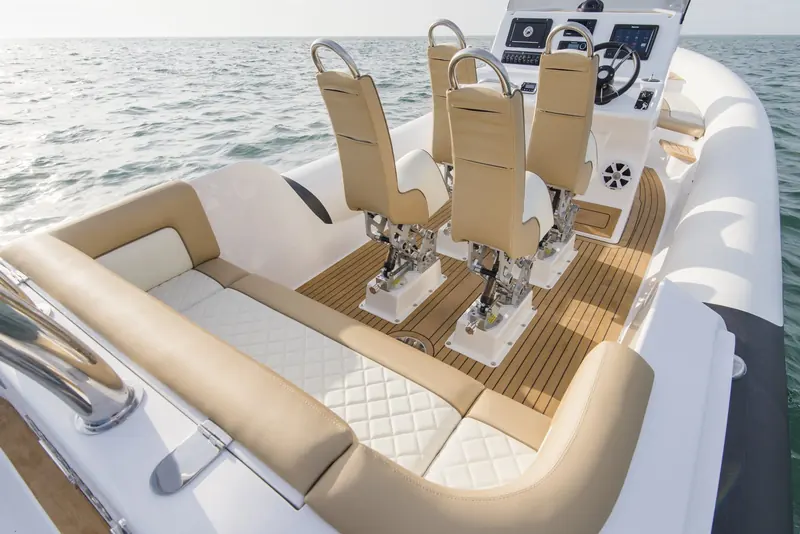 Flexiteek teak-effect decking with black caulking laid across the cockpit sole of a Ribeye Prime 821 RIB, running between the helm seats and the aft bench.
