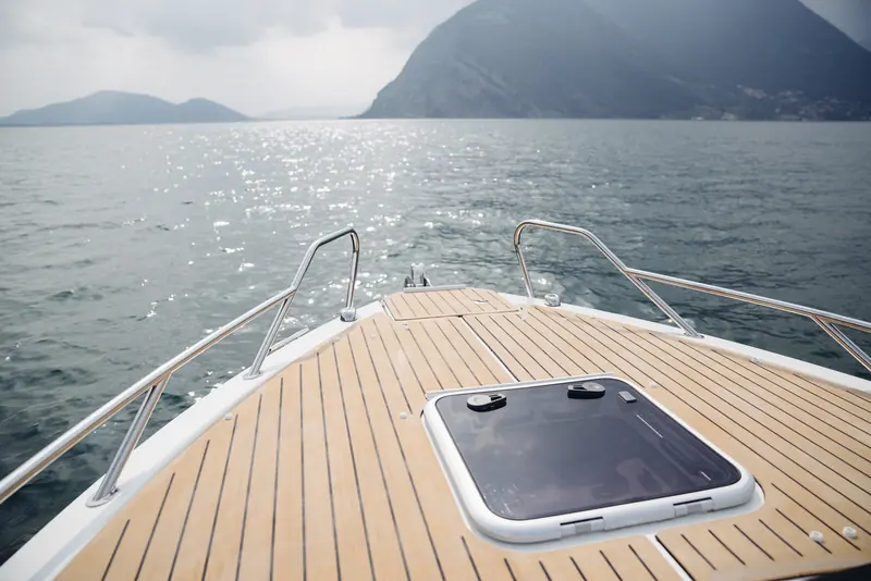 The foredeck of a Quicksilver Activ 675 under way, Flexiteek decking fitted around a forward hatch with the caulking lines converging at the bow.