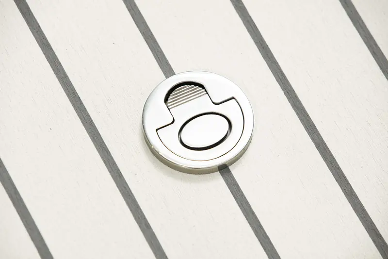 Close-up of a Flexiteek deck fitting set into the plank and caulking pattern, showing the surface texture and seam detail at close range.