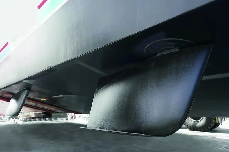 A Humphree interceptor blade mounted on a hauled-out transom, alongside its shaft seal and mounting plate: the vertical blade that drops into the flow under the hull to generate lift, with no hydraulics anywhere in the system.