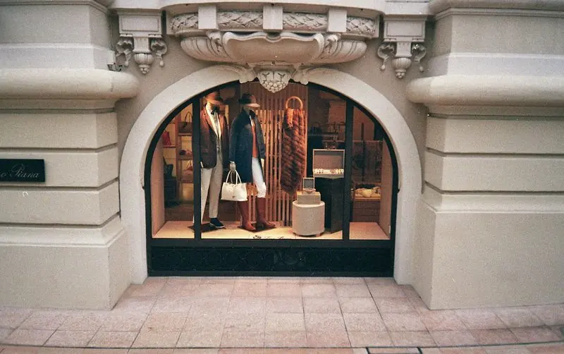 Mannequins in autumn layers fill the arched window of the Loro Piana boutique in Monaco.