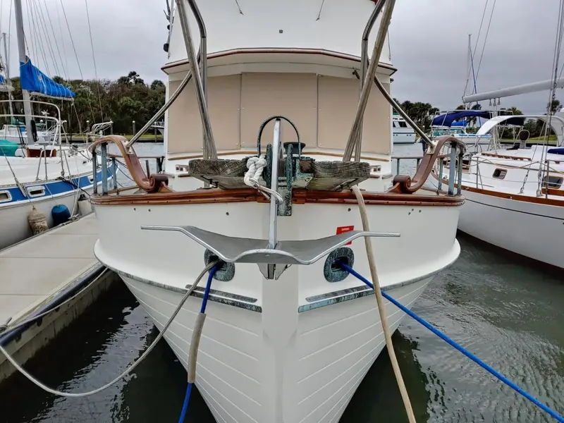The Grand Banks 36's bow head-on, showing how the M2 anchor tucks between the bow rails and the teak rubbing strake without fouling the pulpit.