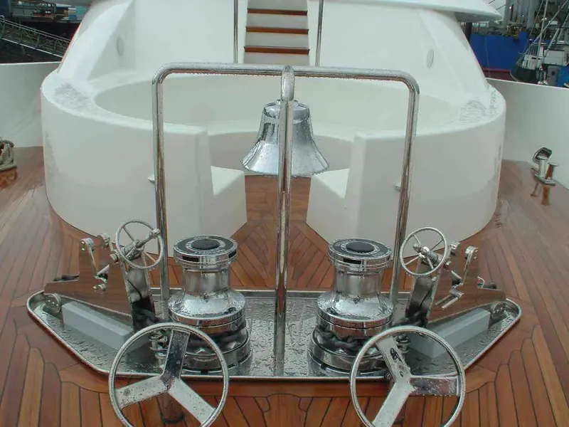 Twin Maxwell VWC6000 capstans on a sailing yacht's teak foredeck, flanking the ship's bell, rigged with 16 mm chain.
