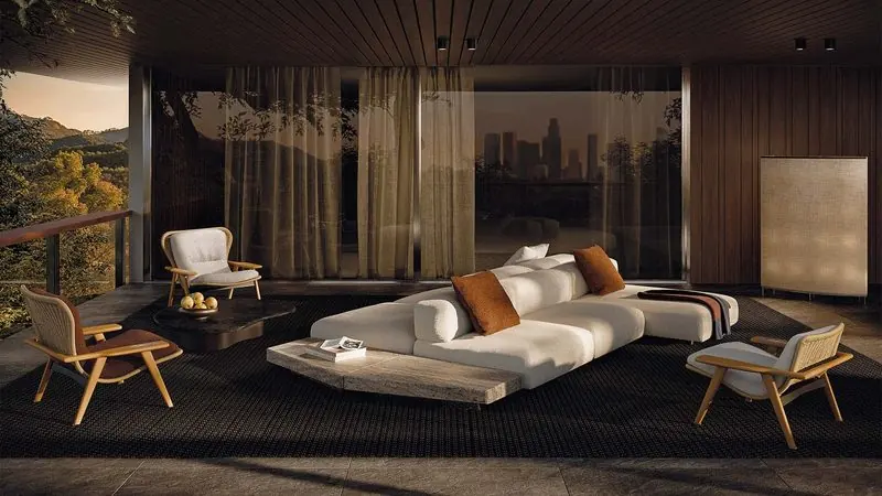 Evening light fills a timber-lined room where a low white sectional faces open glass and the hills beyond.