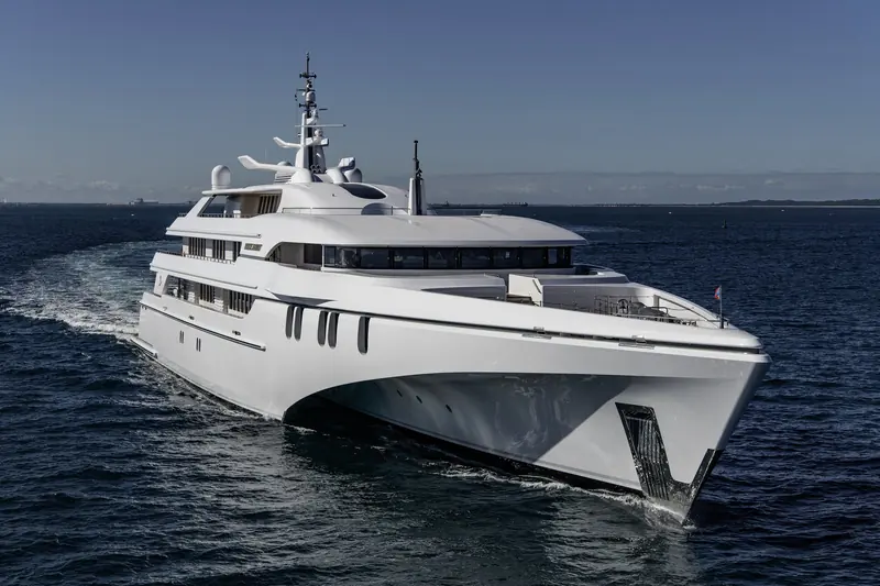 A fast motor yacht with a deep-vee planing hull and twin waterjet troughs cuts a wake at speed, the underway condition where fin stabilisers, unlike a gyro, keep working as speed builds.