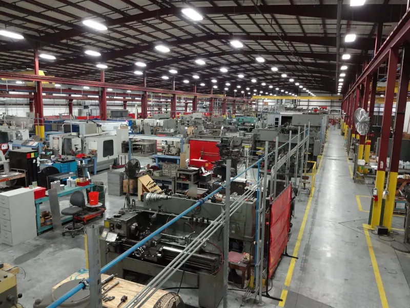 Rows of CNC lathes and fabrication machinery fill the manufacturing floor where the davits and cranes are built.