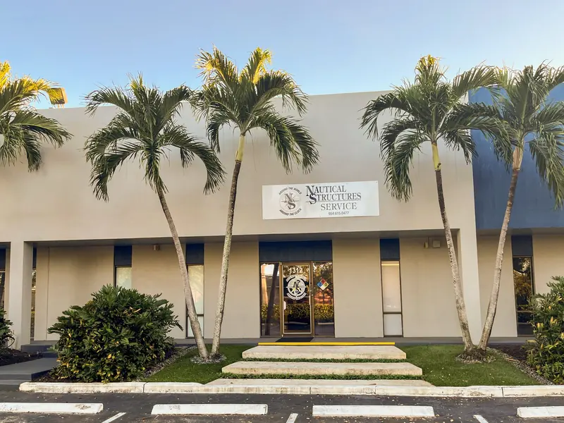 Palm trees line the entrance to the Fort Lauderdale service office, its sign reading Around the World, Around the Clock.