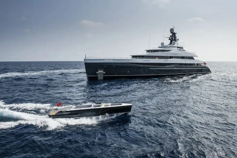 A Pascoe limousine tender runs at speed past a superyacht lying at anchor.
