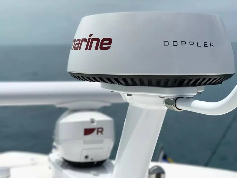 A Raymarine Cyclone Doppler radar array mounted on a boat's hardtop, the radome and open array scanner in close-up.
