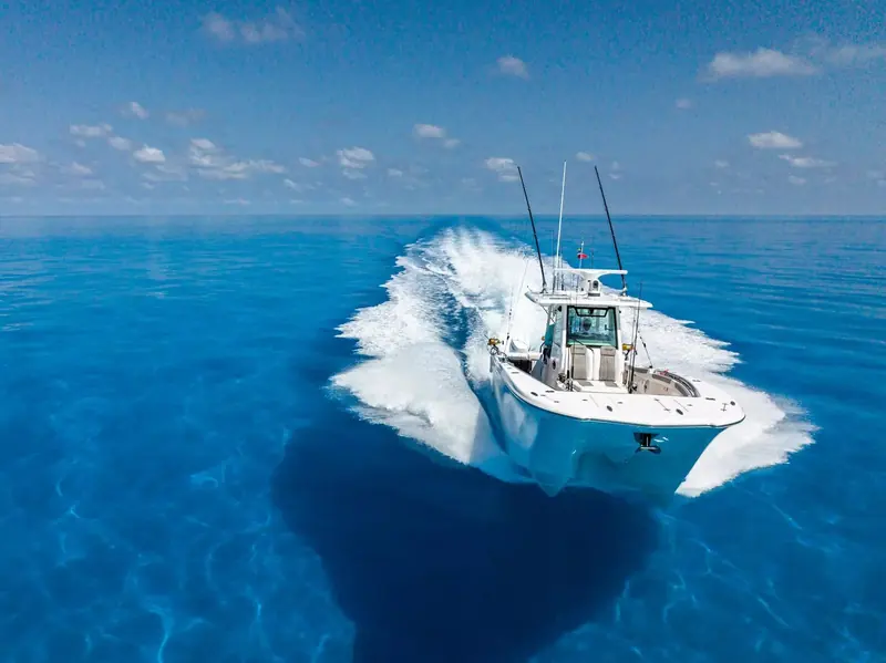 A center console fishing boat running at speed, equipped with Raymarine electronics on the hardtop.