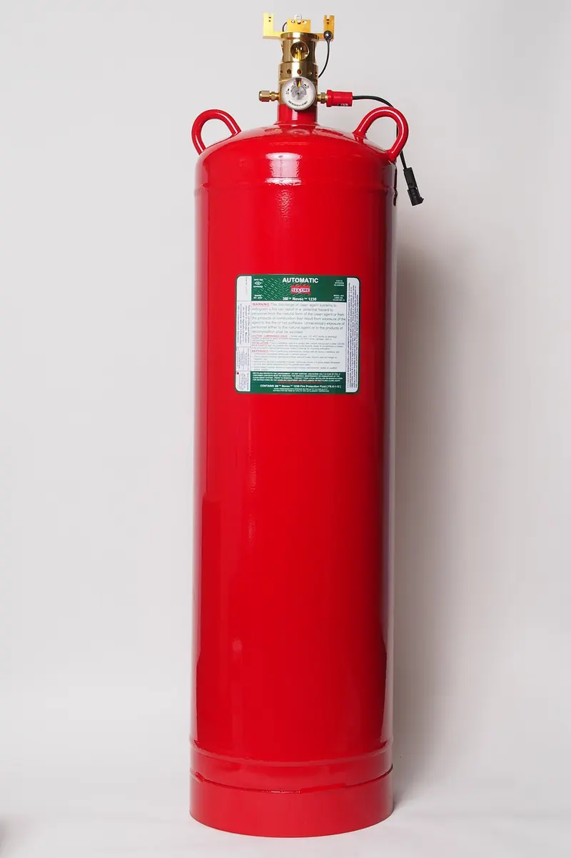 A single tall red cylinder with a plain welded top stands alone against a white background, its green identification label wrapped around the lower body.
