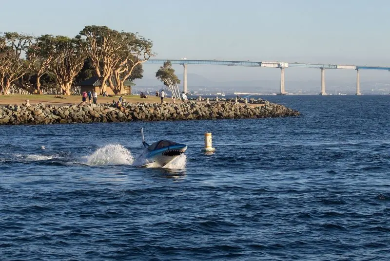A Seabreacher lifts its nose clear of the water in San Diego Bay with the Coronado Bridge behind.