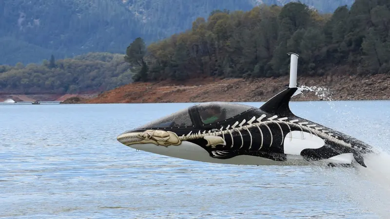 An orca-liveried Seabreacher clears the water on a Northern California lake, its dorsal snorkel throwing a jet of spray.