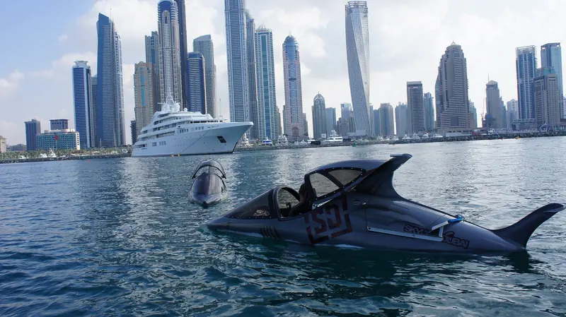 Two Seabreachers idle off the Dubai Marina skyline, one flipped hull-up, with a superyacht and the city's towers behind.