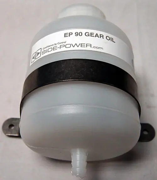 An EP90 gear-oil reservoir fitted to an older Side-Power thruster leg. Sleipner sealed its gear-legs from the factory between 2006 and 2008; a reservoir like this one on a used boat marks the older, oil-fed design that still needs a periodic top-up.