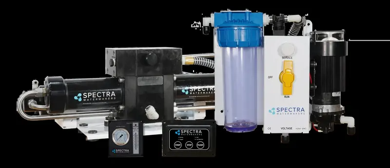 A Spectra Ventura 150R watermaker module on its mounting rail, showing the black membrane housing, clear pre-filter bowl, control panel with power and low-pressure lights, and a pressure gauge along the base