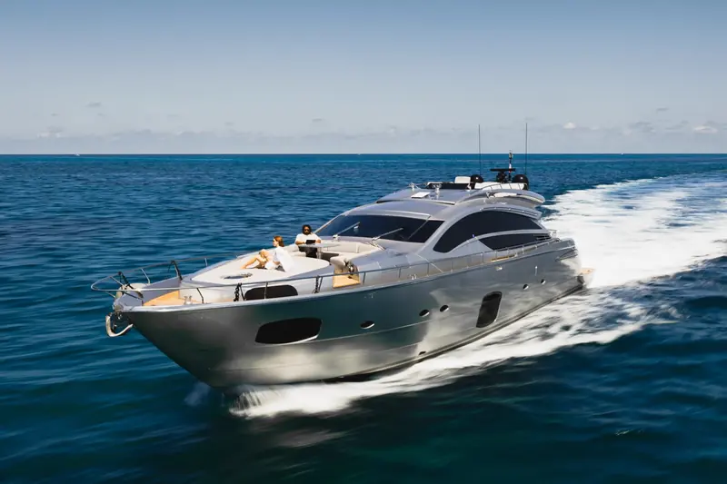 An open-deck flybridge motor yacht at speed with two people seated aft, one of the yacht-market scenes from the same Starlink Maritime page; the two black domes on the arch are radar and a searchlight, not the Starlink antenna, which sits elsewhere on the boat.