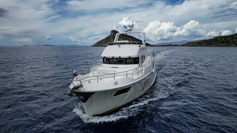 Awanui NZ underway off an island coastline. The Nordhavn 51 carries a TRAC digital fin stabilizer system, fitted to hold the boat level at cruising speed and at rest at anchor.