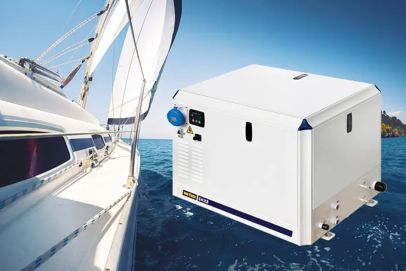 A VETUS marine generator sits mounted in a sailboat's open cockpit locker, its control panel and cooling vents visible against the boat's sails and rigging.