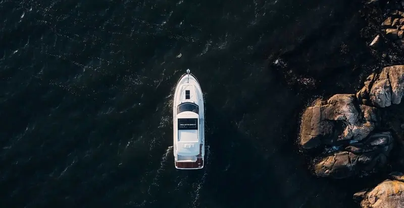 A planing motor yacht on IPS running close to shore, the shallower running angle IPS gives a hull compared with a shaft installation.