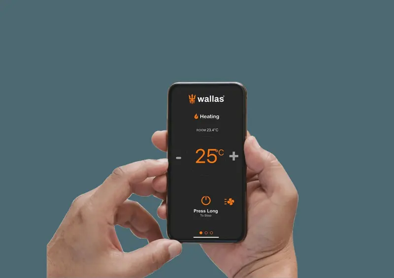A hand holds a phone running the control app, the cabin heating set to 25 degrees.