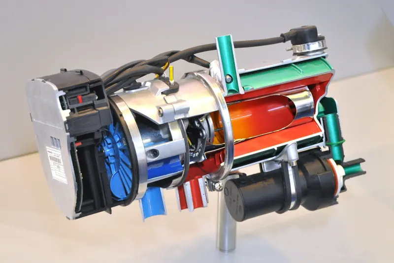 A cutaway Webasto Th 90 S hydronic diesel heater, the control and combustion unit that heats coolant for cabin fan heaters and hot water rather than blowing warm air directly