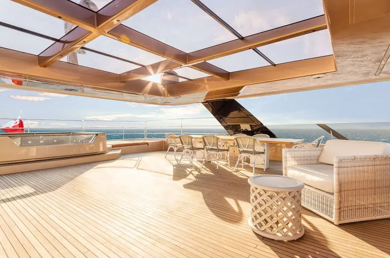 The flybridge bar and seating area, set beneath the same sliding glass canopy that shelters the deck below.