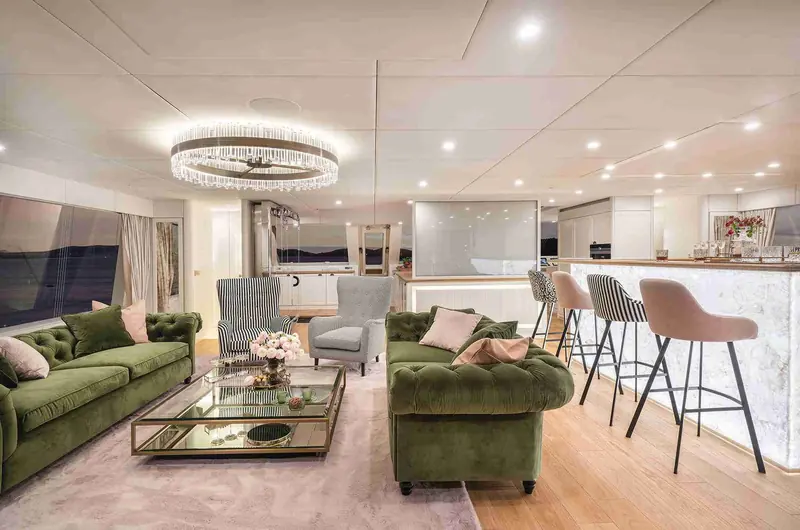 The main saloon, open-plan to the galley and bar, finished in the owner's chosen palette rather than a standard specification.