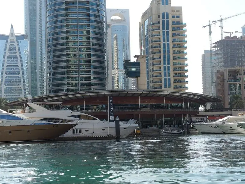 Yachts berthed in front of the Dubai Marina Yacht Club clubhouse on a bright morning