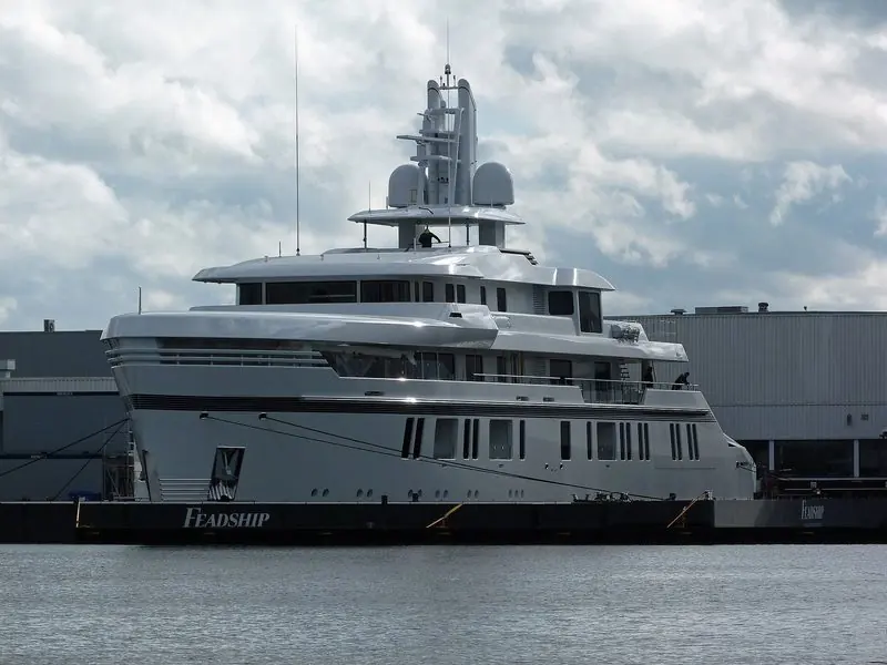 Alongside at Aalsmeerderbrug, a white motor yacht sits under the yard sheds.