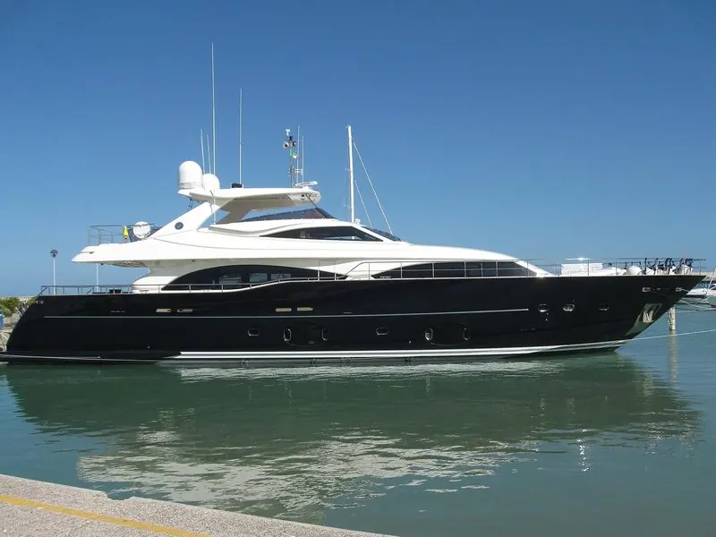 Ferretti Custom Line 97 motor yacht with a dark blue hull moored in the port of Fano, Italy