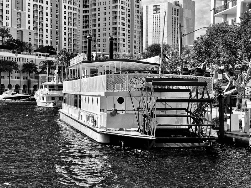 Black-and-white view of the paddlewheel sightseeing boat Carrie B docked on the New River in downtown Fort Lauderdale
