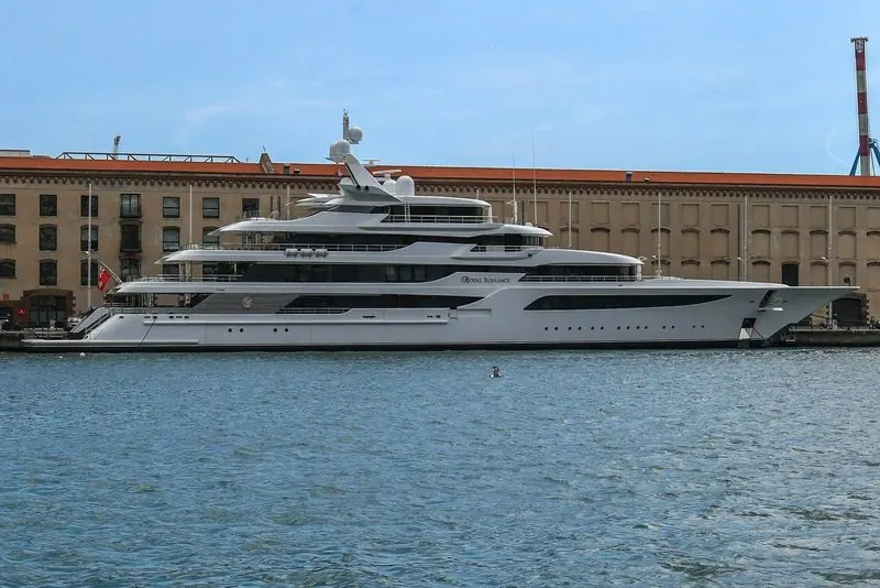 A very large motor yacht lies against the old cotton warehouses in the port of Genoa.
