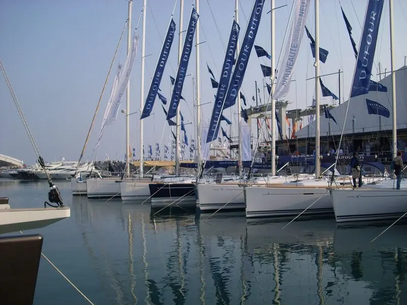 Rows of new sailing yachts sit bows on under builders' banners at the Salone Nautico.