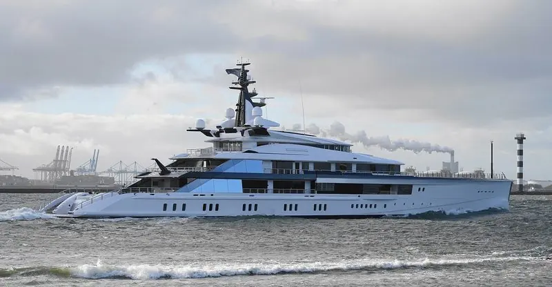 A large motor yacht runs out past the container cranes at Hoek van Holland.