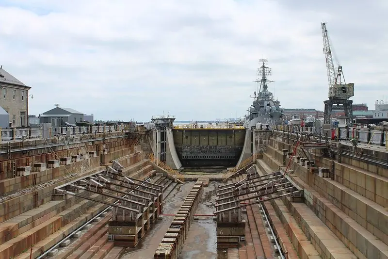 An empty granite graving dock with keel blocks at the historic Charlestown Navy Yard in Boston